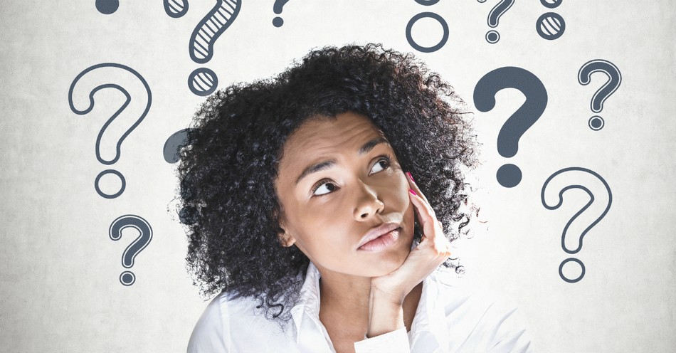 A woman deep in thought surrounded by question marks