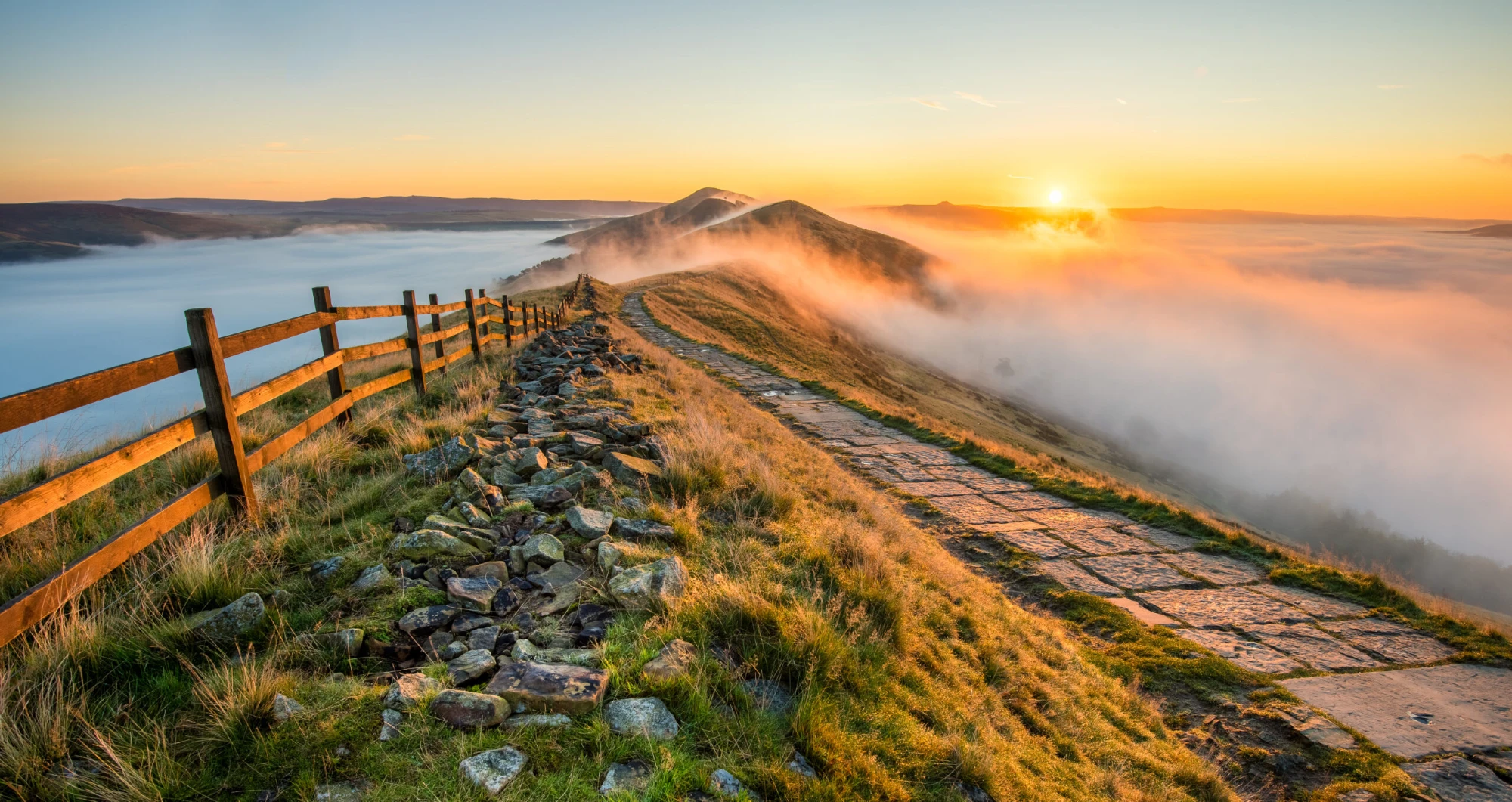 The Mam Tor ridge at sunrise with mist over the valley