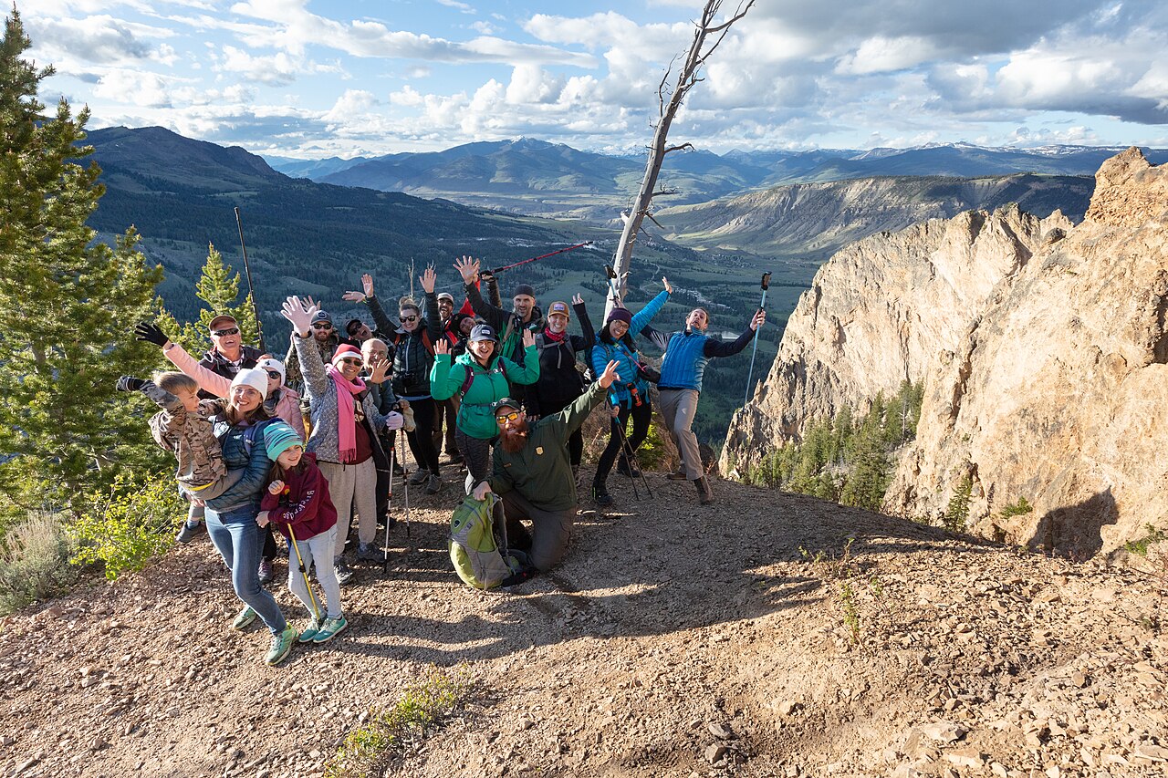 Diverse group of hikers celebrating at a mountain summit